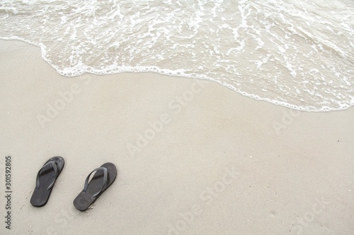 Brown sandal on the white sand