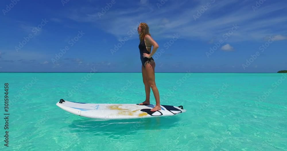 standing girl with sunglasses on floating surf board at sea of bermuda standing girl with sunglasses on floating surf board at sea of bermuda