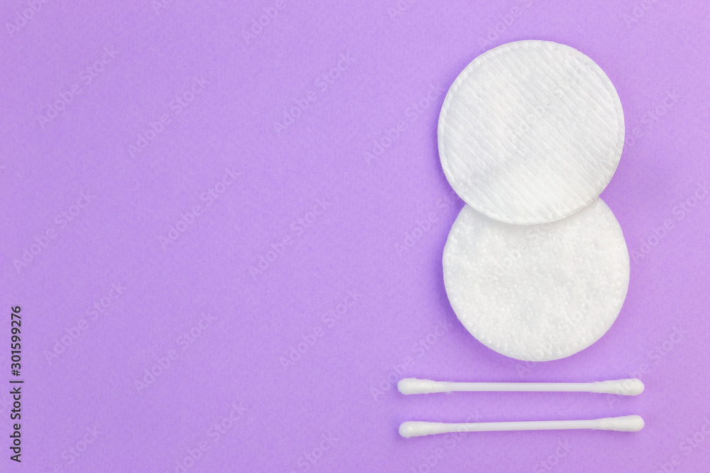 © Garmon - Flat lay composition with cotton hygienic products on pastel violet background with copy space. © Garmon - Flat lay composition with cotton hygienic products on pastel violet background with copy space.