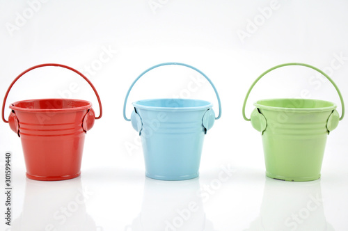 Three metal buckets of different colours with handle