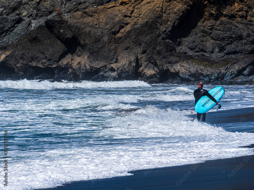 Naklejka premium California Surfer and his turquoise Board enjoy the sea
