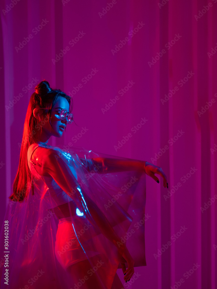 Cyberpunk and neon, a young trend girl in a transparent latex Cape.