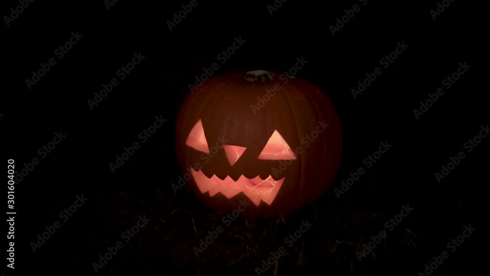 Glowing Halloween pumpkin on the night dark moody style panning and rack focusing camera Glowing Halloween pumpkin on the night dark moody style panning and rack focusing camera