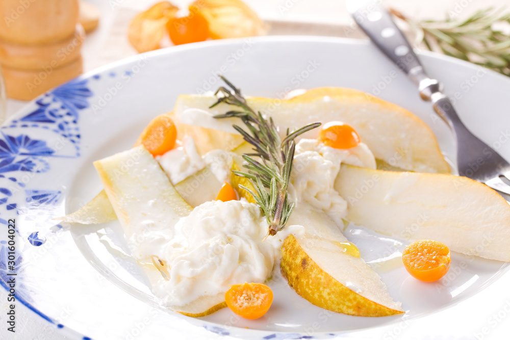 Fototapeta premium traditional pear and cheese salad on a white plate