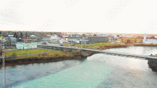 Bridge Over Olfusa River, Selfoss City, Iceland. Aerial View of Alpine Water Flowing Between Riverbanks photo