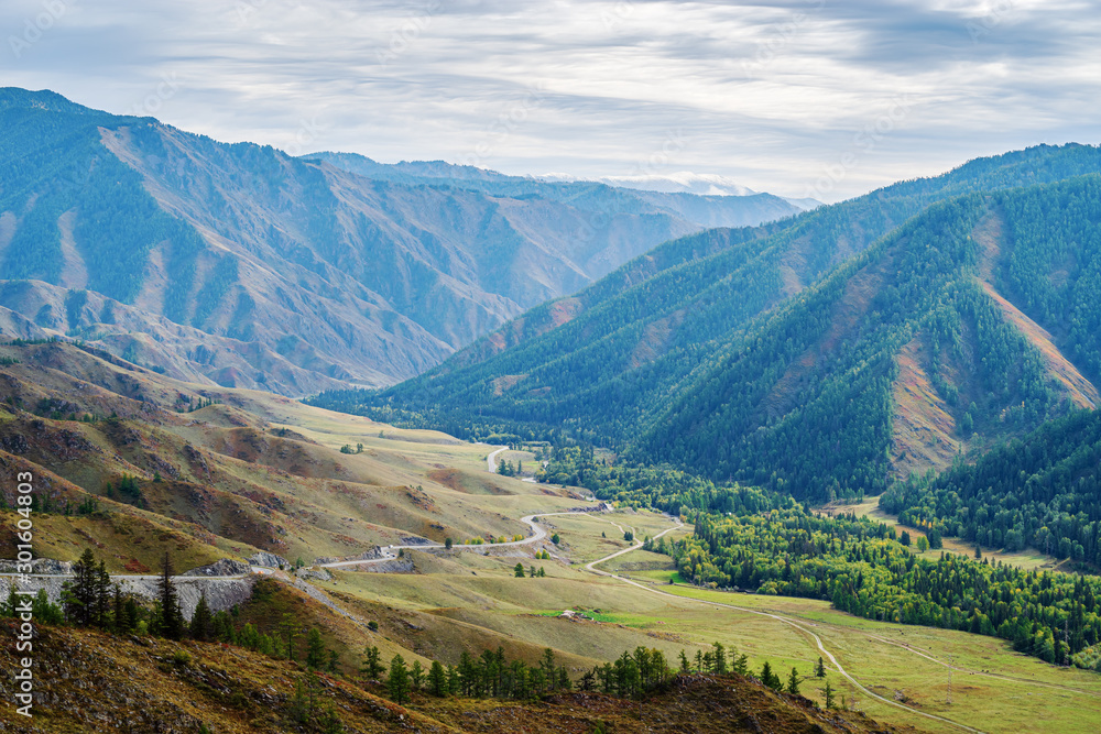 Serpentine mountain road. View of the Chuysky tract from the Chike-Taman pass, Altai mountains, Russia Serpentine mountain road. View of the Chuysky tract from the Chike-Taman pass, Altai mountains, Russia