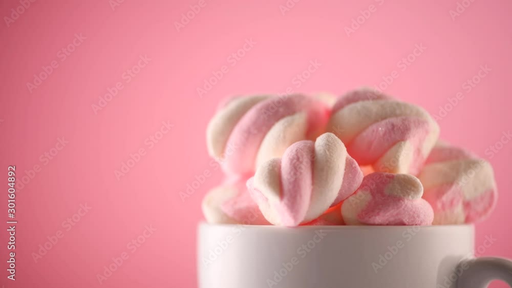 Marshmallow. Close-up of Marshmallows colorful chewy candy, rotation over pink background. Sweet food dessert in a cup with hot chocolate close-up. 4K UHD video Marshmallow. Close-up of Marshmallows colorful chewy candy, rotation over pink background. Sweet food dessert in a cup with hot chocolate close-up. 4K UHD video