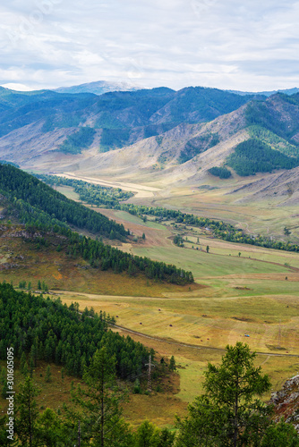 The Maly Ilgumen river valley, the snow-capped peak of Mount Akkem on the horizon. View from the Chike-Taman pass, mountain Altai, Russia