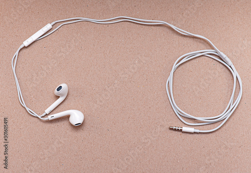 White Headphones on soft brown Paper with space for Text or Ideas, Wire and Earphones, Business concept Picture