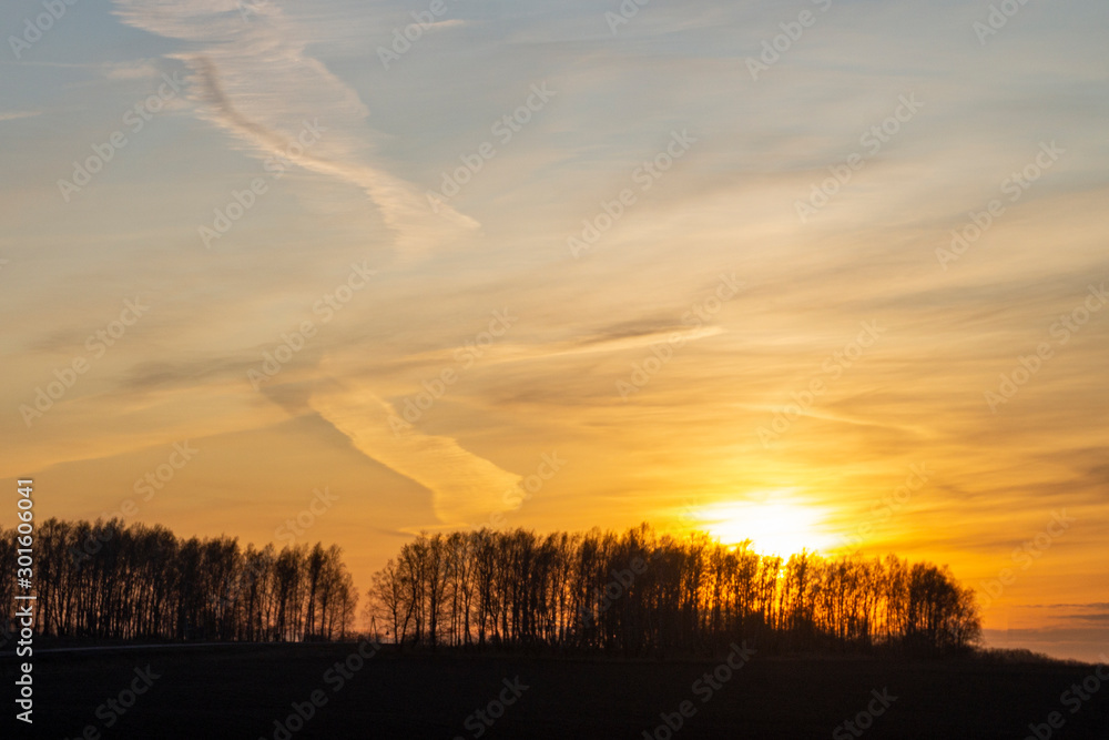Fototapeta premium Sunrise on a frosty autumn morning. Picturesque clouds on the orange sky.