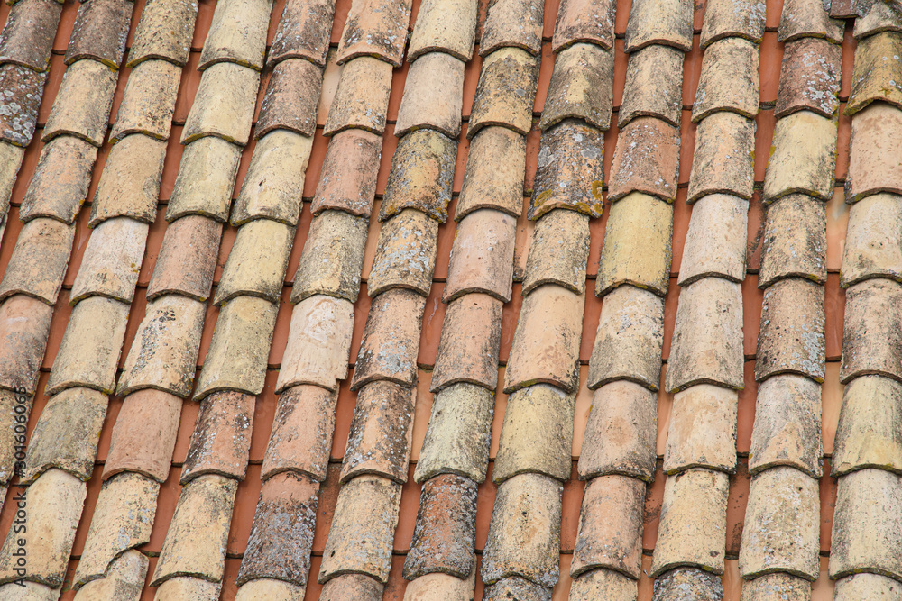 Fototapeta premium Fragment of a tiled roof. Clay tiles. Background. Pattern. Terracotta. Gray. Ocher.