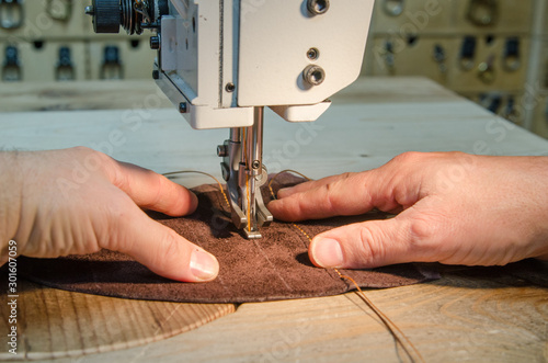 Man working with leather using leather sewing machine 