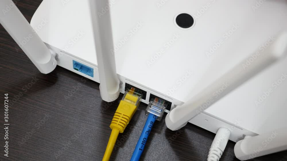 Top View Elderly Man Hand Unplugging White Internet Cable From Wireless Router With Yellow And Blue Cables. Top View Elderly Man Hand Unplugging White Internet Cable From Wireless Router With Yellow And Blue Cables.