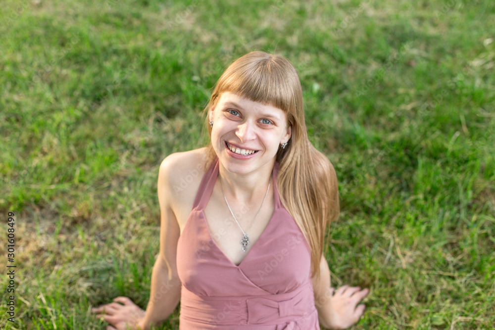 girl in pink dress sitting on the grass girl in pink dress sitting on the grass