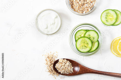 Homemade cosmetics with cucumber and yogurt and oatmeal on a white background. Ingredients for the mask