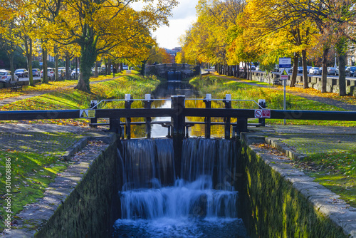 Canal lock gates at historic Grand Canal, Dublin, Ireland. Colorful Autumn foliage, flowing waters, towpaths, canal banks. McKenny's Bridge  / Conyngham Bridge. 