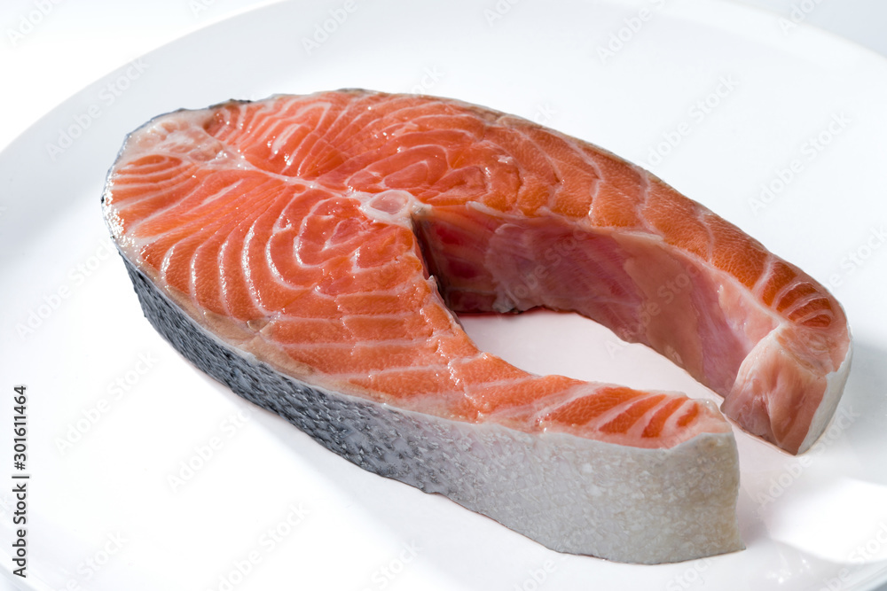 Salmon steak on a white plate isolated on white background.. Salmon steak on a white plate isolated on white background..
