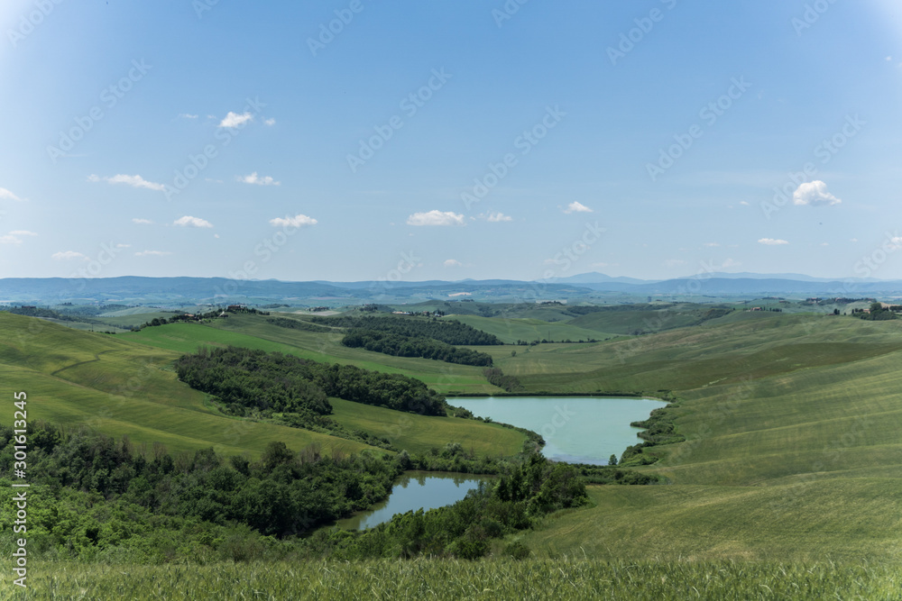 landscape with, ponds, green fields and blue sky in Tuscany, Italy landscape with, ponds, green fields and blue sky in Tuscany, Italy