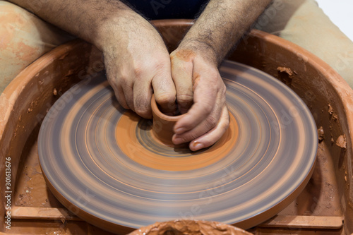 hands that shape the clay pottery Turning