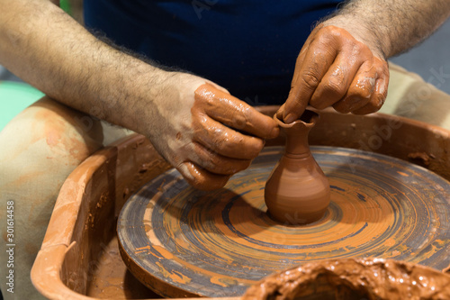 hands that shape the clay pottery Turning