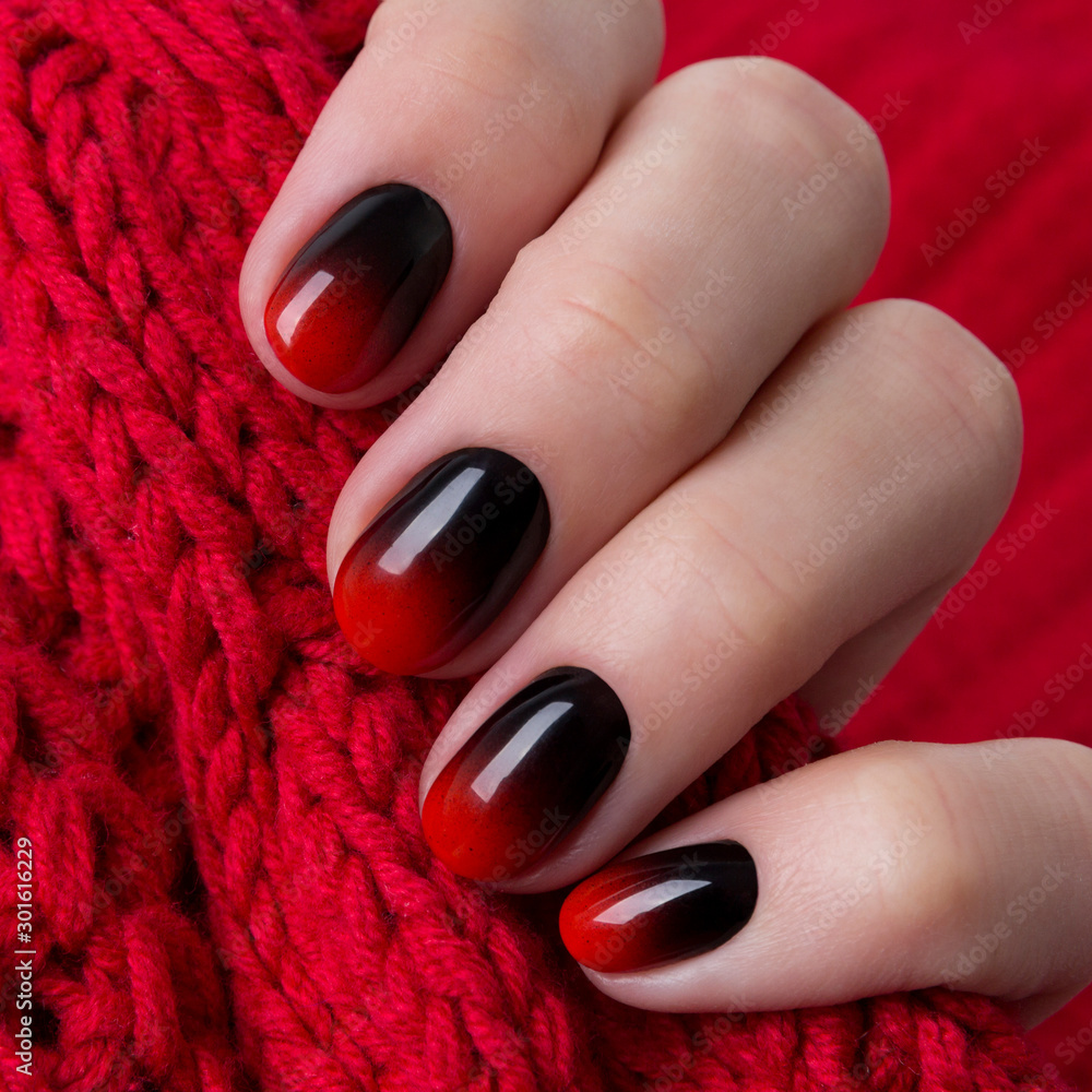 Female hand with red black ombre gradient nails hold wool textile fabric  Stock Photo | Adobe Stock