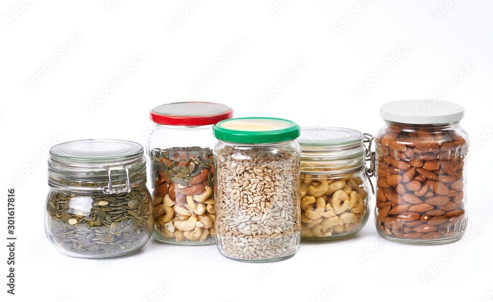 Nuts and seeds in jars on white background Nuts and seeds in jars on white background