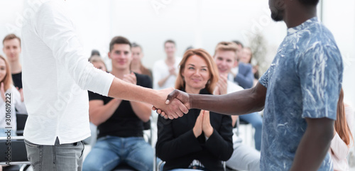 young men shake hands before the start of the briefing