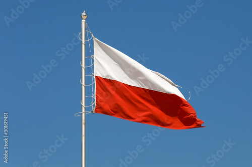 Flag of Poland is seen against the blue sky