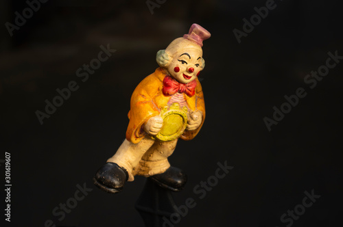 Fröhliche Clownsfigur als Spielzeug mit einem Lächeln im Gesicht auf einen Zaun aufgesteckt