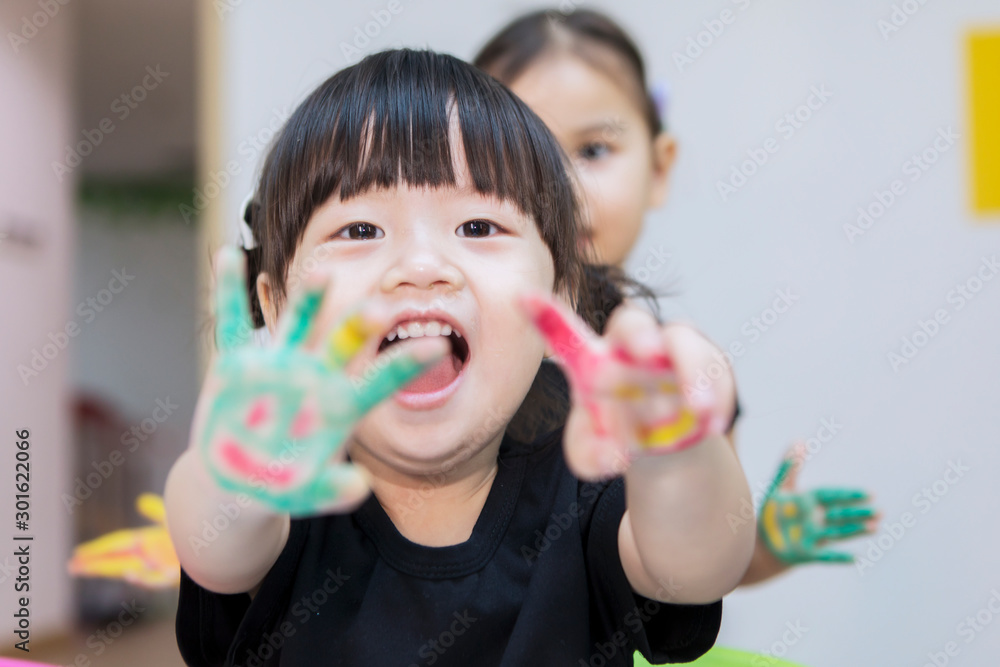Asian little girl shows painted hands with her friend