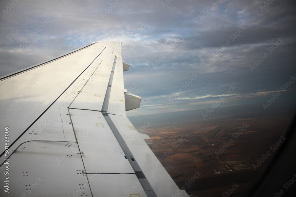 Wing of an airplane flying above the clouds. Travelling concept Wing of an airplane flying above the clouds. Travelling concept