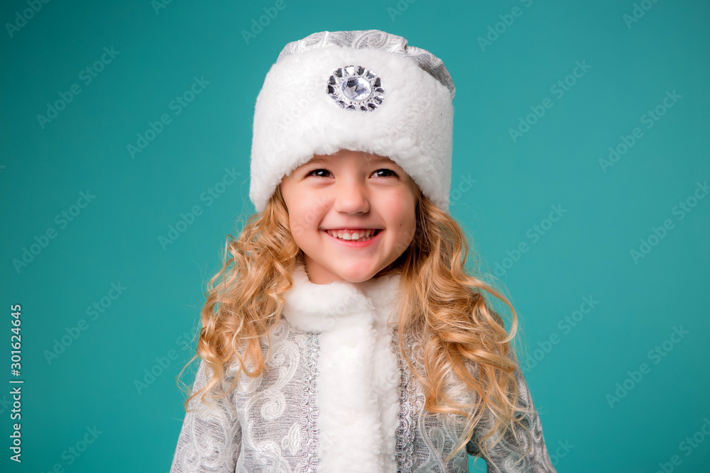 little blonde girl smiling in snow maiden costume isolate on blue background, baby catches snowflakes little blonde girl smiling in snow maiden costume isolate on blue background, baby catches snowflakes