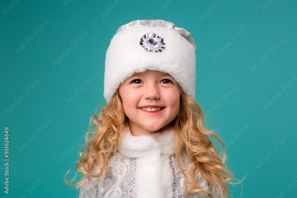 little blonde girl smiling in snow maiden costume isolate on blue background, baby catches snowflakes little blonde girl smiling in snow maiden costume isolate on blue background, baby catches snowflakes