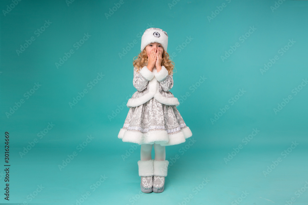 little blonde girl smiling in snow maiden costume isolate on blue background, baby catches snowflakes little blonde girl smiling in snow maiden costume isolate on blue background, baby catches snowflakes