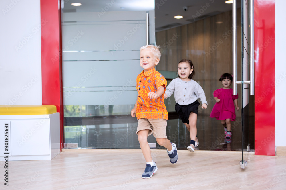 Fototapeta premium Cute schoolchildren running outside after studying