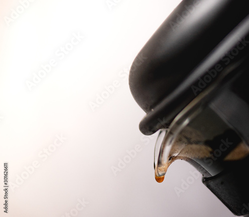 Coffee being poured into a cup against a white backdrop