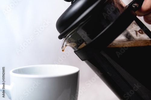 A french press tipping over to pour coffee