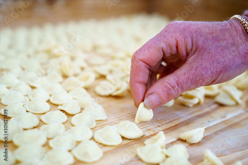 Hands making orecchiette pasta, typical of Apulia, a region of Southern Italy. Their name comes from their shape, which resembles a small ear.