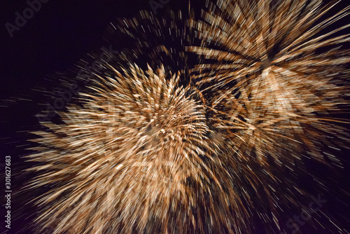 Explosion of fireworks in the dark sky, giving the impression of movement,blurred background.Shot taken at high ISO.