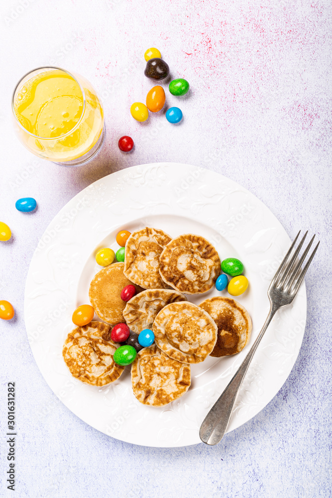Dutch mini pancakes called poffertjes with colorful candies. Healthy food concept, flat lay, top view, copy space. Dutch mini pancakes called poffertjes with colorful candies. Healthy food concept, flat lay, top view, copy space.