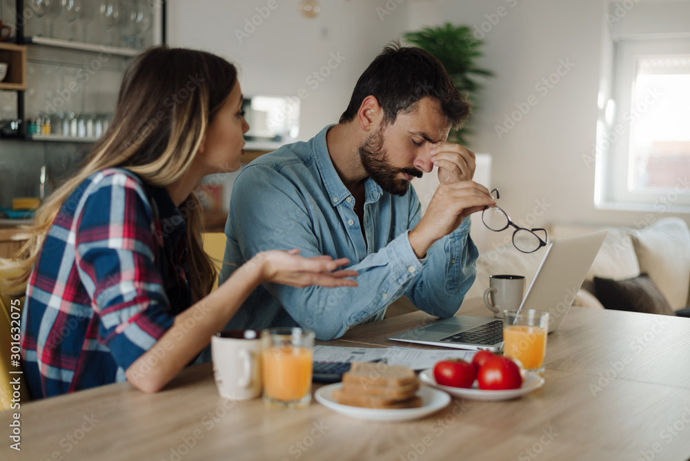 Young couple feeling stressed while have to pay their bills over Internet Young couple feeling stressed while have to pay their bills over Internet