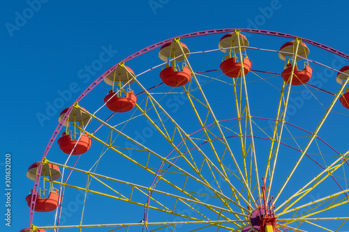 Ferris wheel on a background of blue autumn sky.