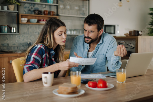 Young couple arguing while having problems with their home finances