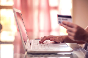 Papier peint photo  Woman holds credit card and does online payment with laptop. Online shopping concept  © Aleksej