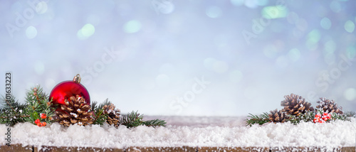 Panoramic view of fir branches and christmas ball on snowy wooden table