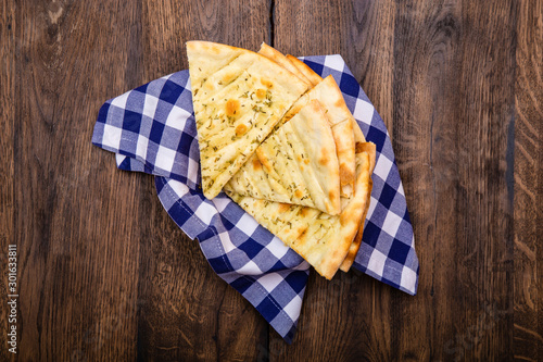 Italian Focaccia with garlic on a wooden background
