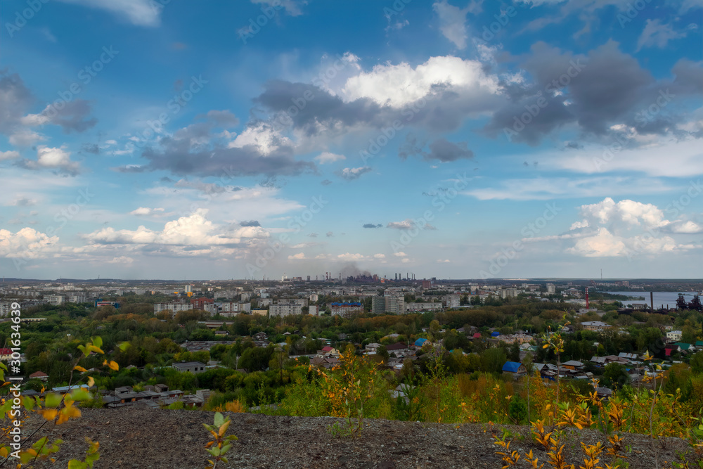 View of the city and the metallurgical plant from the top of the mountain summer landscape.
