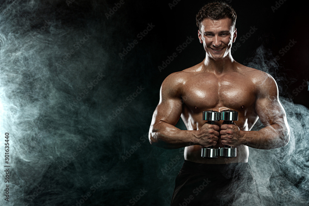 Obraz premium Strong and fit man bodybuilder. Sporty muscular guy with dumbbells. Sport and fitness motivation. Individual sports recreation.