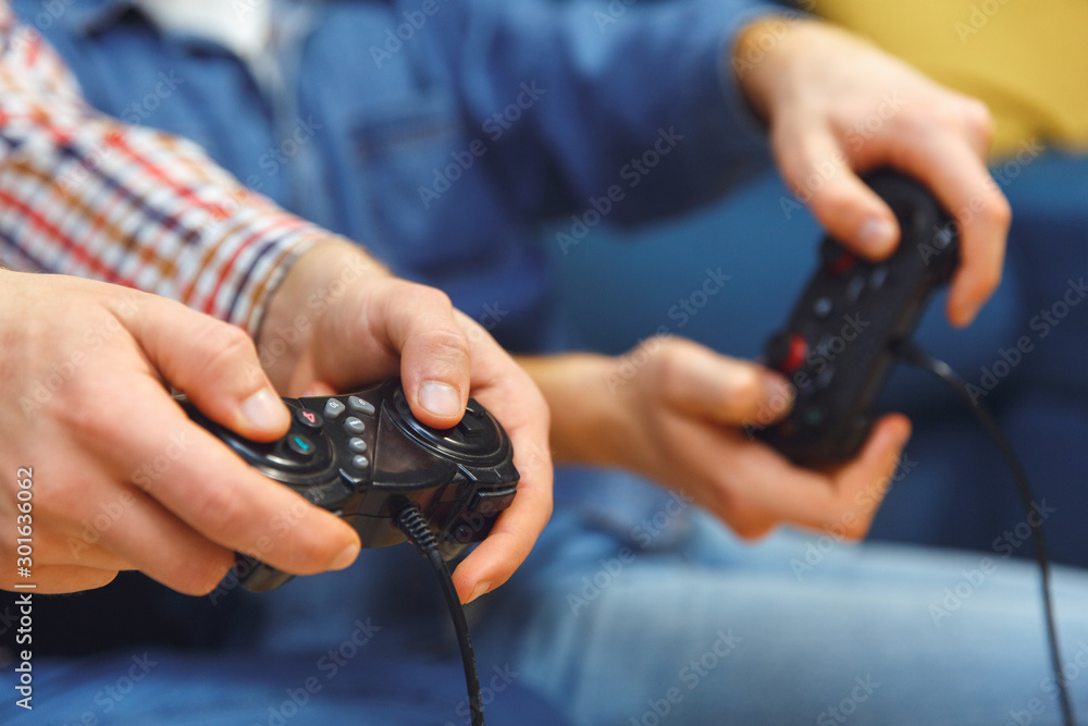 Young men having party indoors fun together playing game console close-up