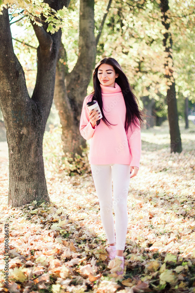 Beautiful woman drink coffee and walking in the park. Beautiful woman drink coffee and walking in the park.
